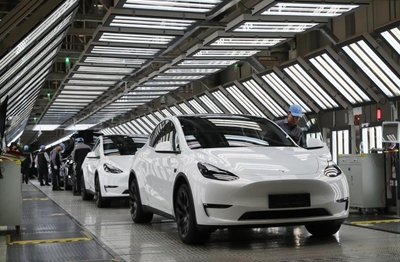 2023年12月22日,在特斯拉上海超級工廠內,工人在對出廠前的車輛進行漆面及門窗檢測。新華社記者方喆攝